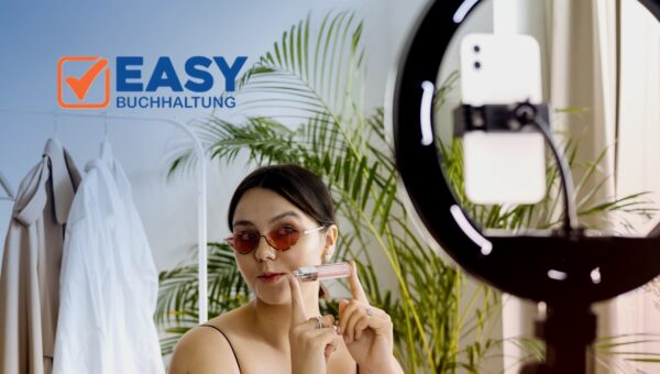 Influencerin präsentiert ein Kosmetikprodukt vor einem Ringlicht mit Smartphone – Logo Easy Buchhaltung